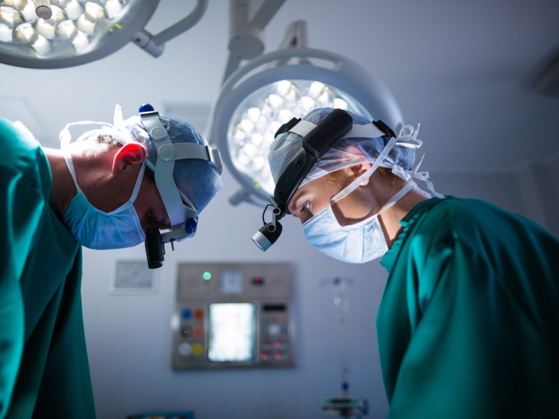 Surgeons wearing surgical loupes while performing operation in operation theater